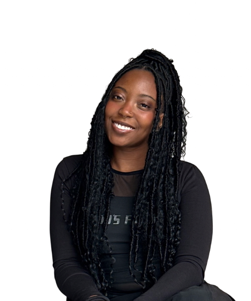 Kamila Yusuf, Arts Reporter & Content Creator, smiles wearing a black long-sleeve shirt.
