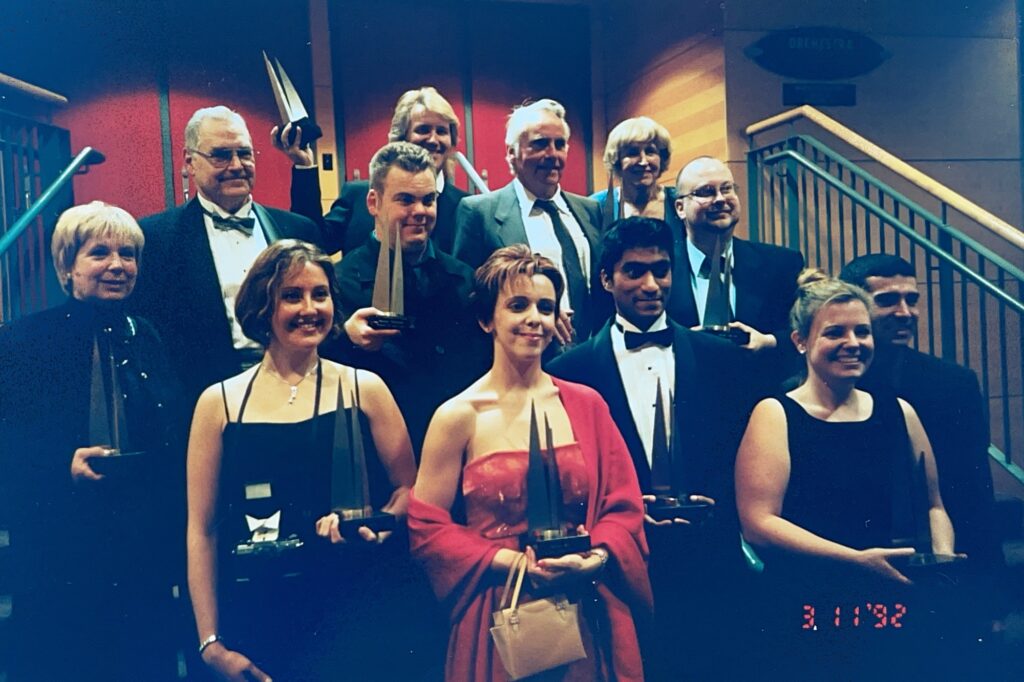 Winners of the 2002 Mississauga Arts Awards hold their metal trophies and stand posed on the steps of Living Arts Centre's Hammerson Hall.