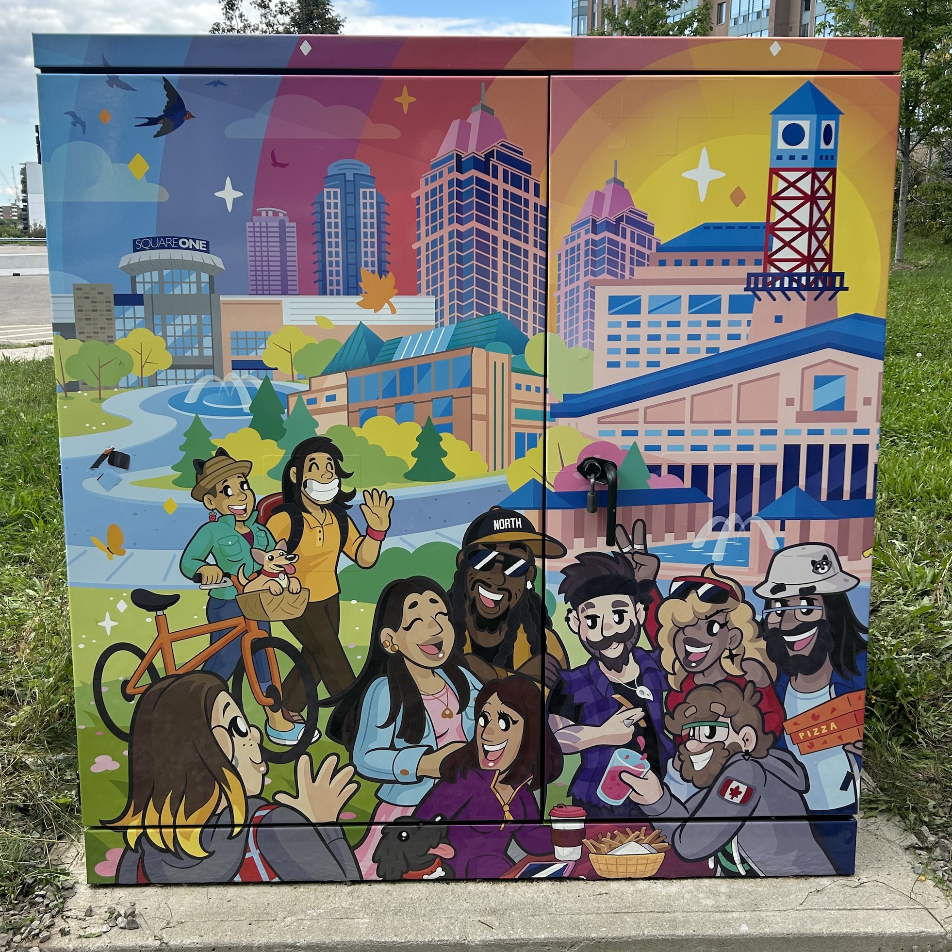 Alectra box covered in a vibrant vinyl mural by Sauga City. The mural features diverse characters smiling outside, with central Mississauga locations and landmarks behind them.