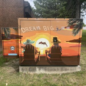 Vinyl wrapped utility box with a digital design by David Anthony. The artwork features a couple on a beach under a sunset with their silhouettes visible from behind.