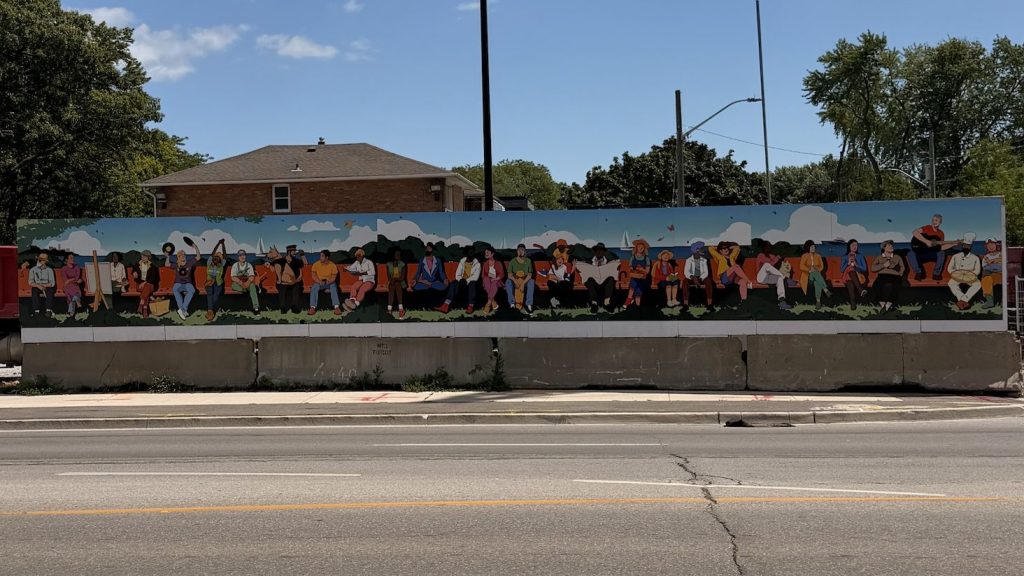 Largescale mural by Jinke Wang. The mural features a diverse group of people from all backgrounds and careers, identifiable by their uniforms, sitting on a long bench spanning the lnegth of the mural.